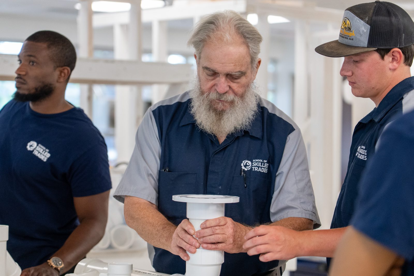 School of Skilled Trades instructor showing students a plumbing fitting