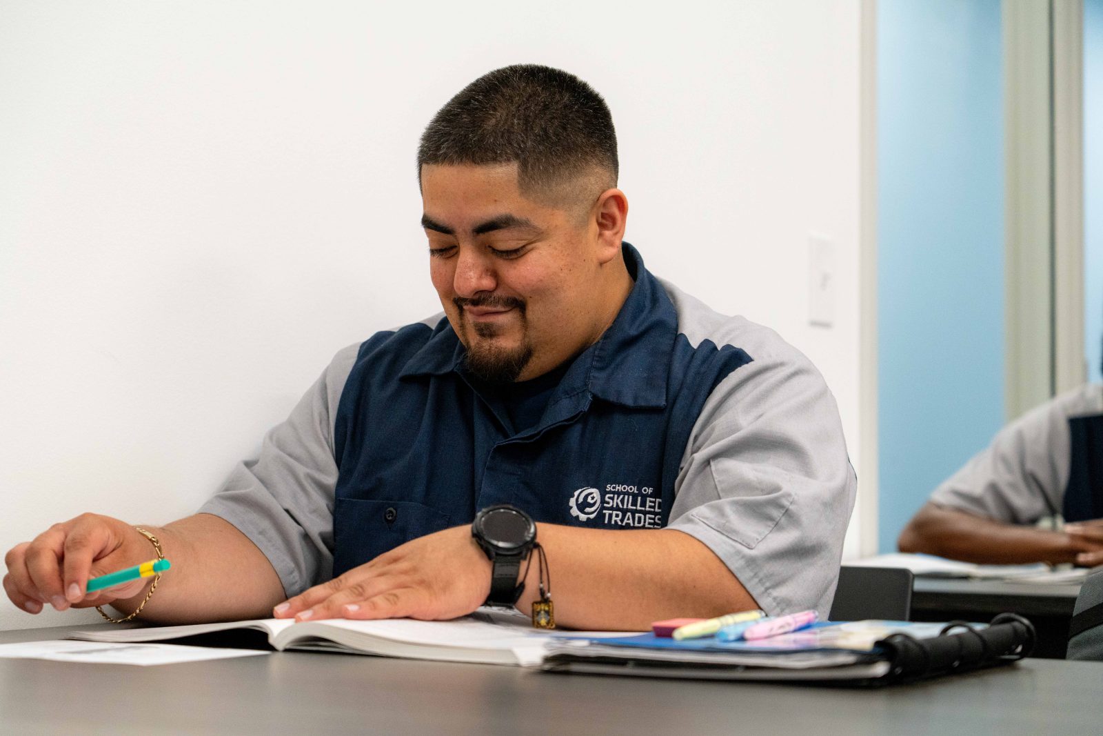 Adult student reviewing course material in a School of Skilled Trades classroom