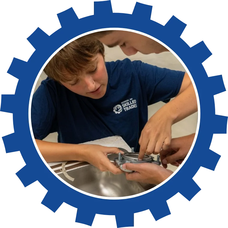 School of Skilled Trades student working on a sink fitting with an instructor