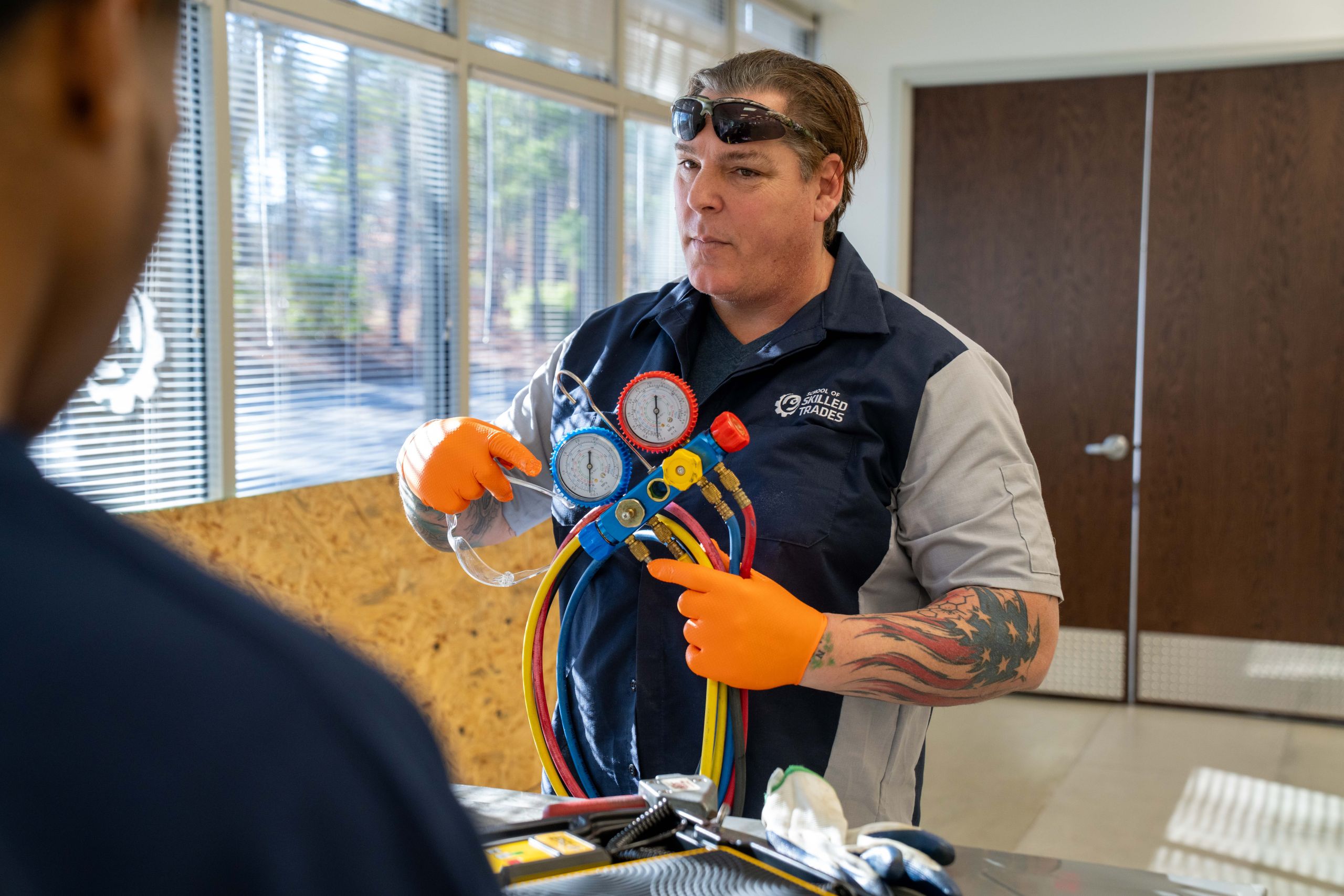 School of Skilled Trades HVAC student checking a system with refrigerant gauges